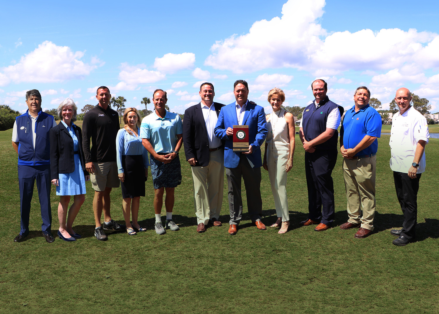 The Sawgrass Country Club team gathers around its Distinguished Club award, which was presented to the local club by BoardRoom magazine.